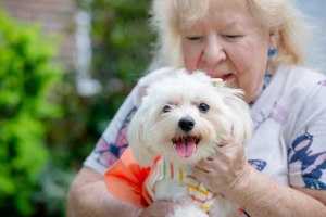 older woman talking to her happy puppy